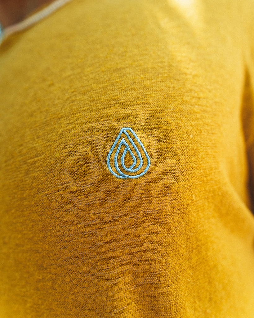 Camiseta de cáñamo amarilla con el logo de Batera Brand bordado en el pecho en azul claro